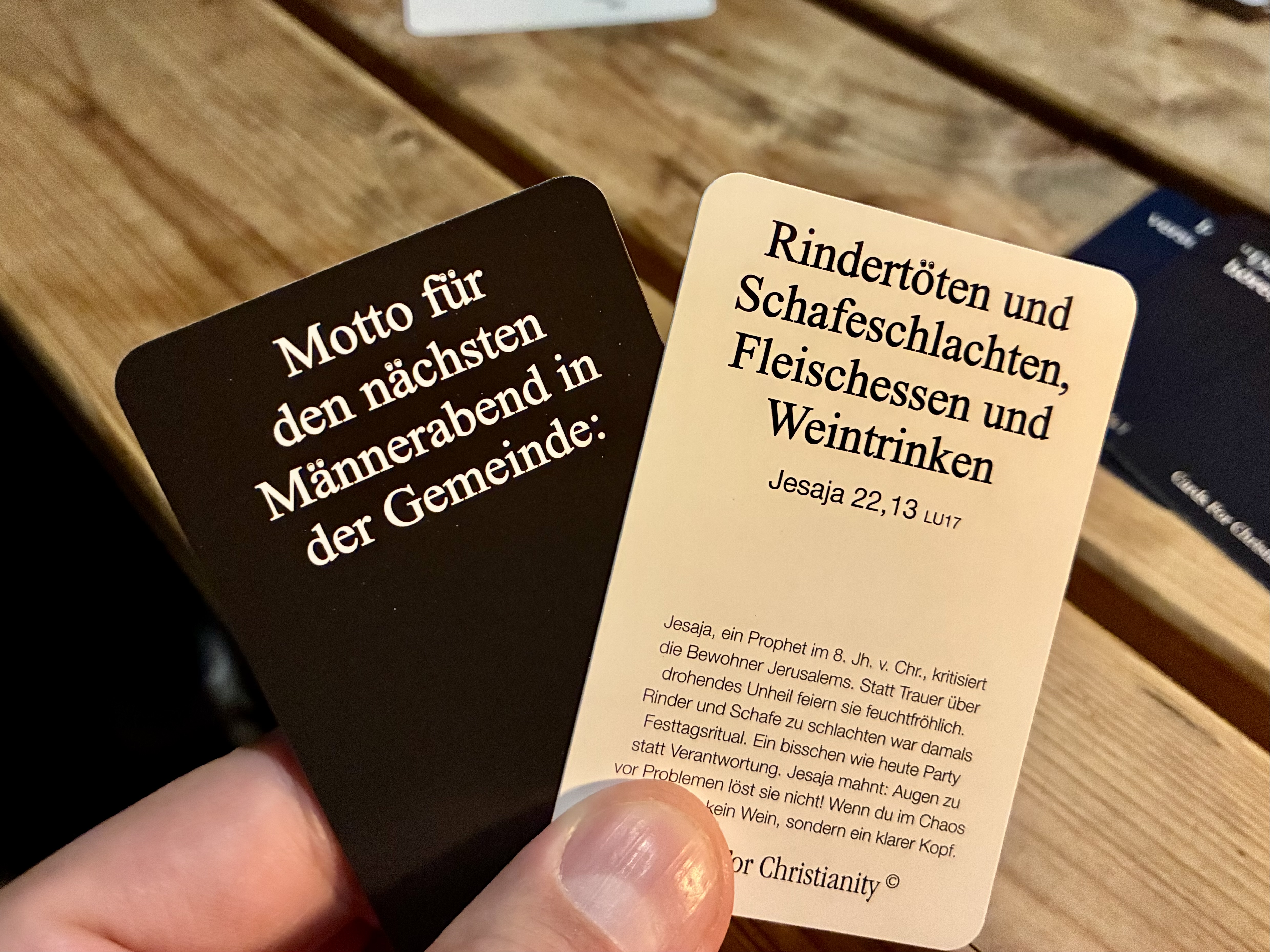 "Zwei Karten des Spiels. Eimal steht: Motto für den nächsten Männerabend: Und auf der anderen dann als Antwort: Rindertöten und Schafeschlachten, Fleischessen und Weintrinken"